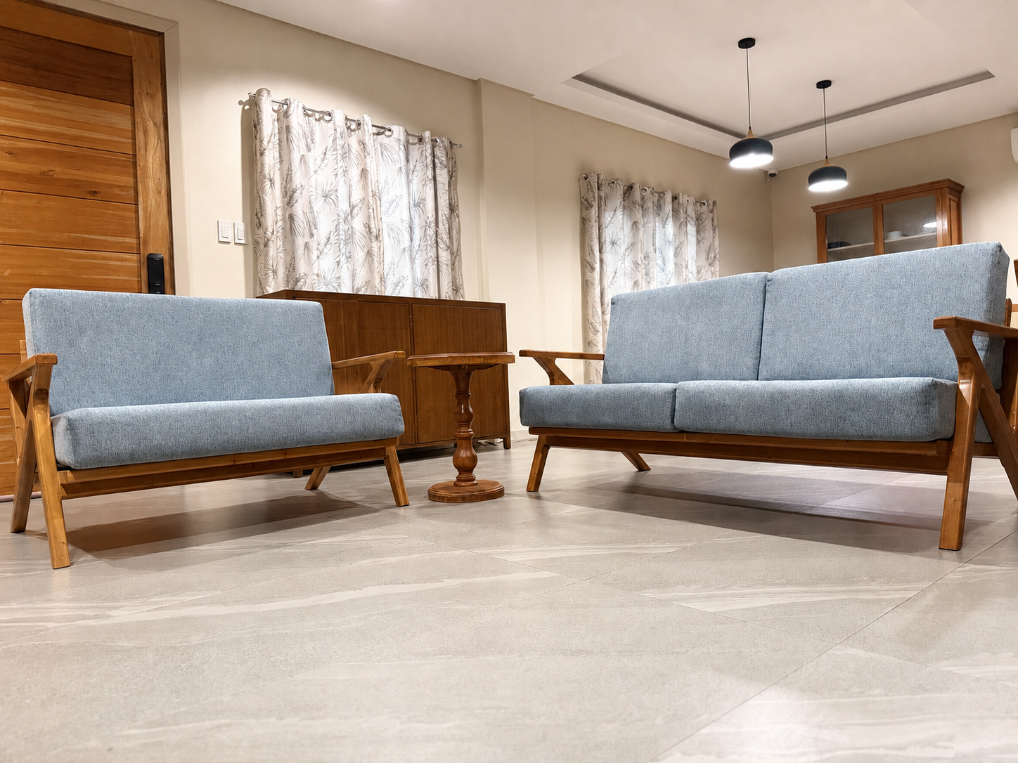 Blue-grey upholstered wooden sala seating in a tidy lived-in home interior.