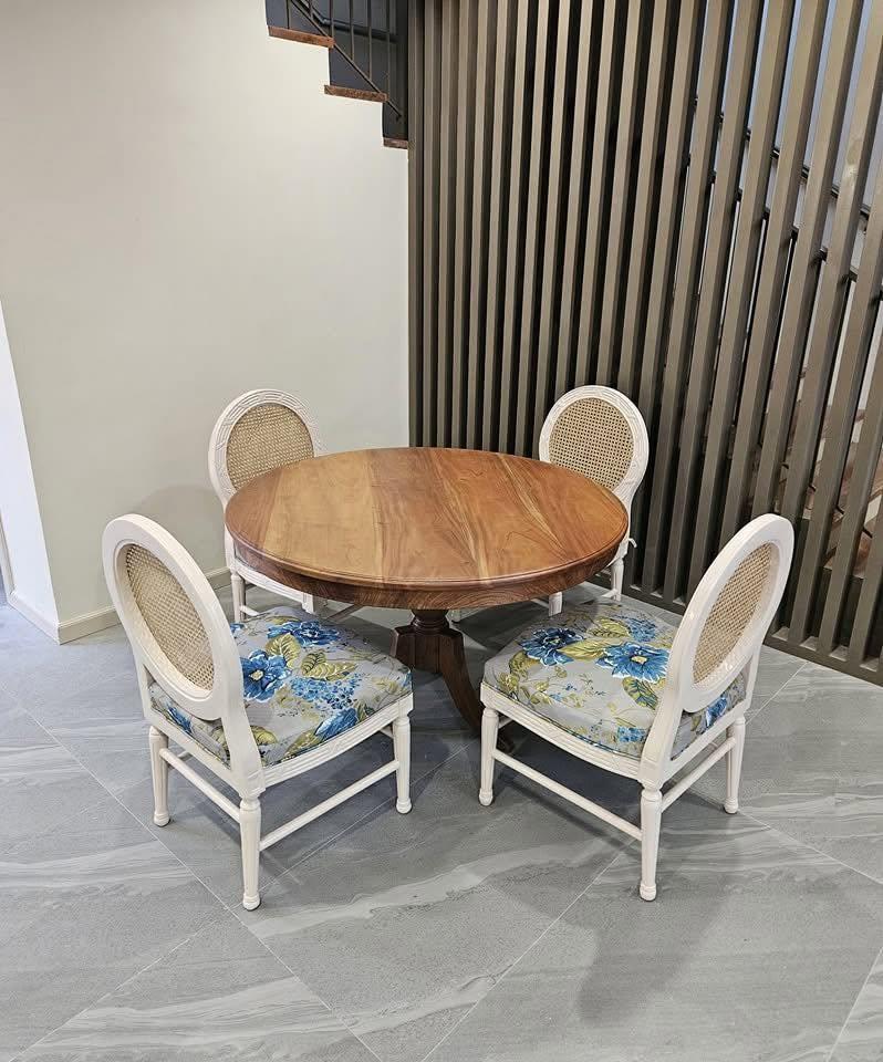 Round wood table with four white cane-back chairs
